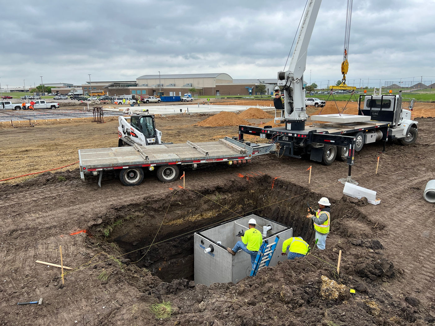 Crane setting underground structure at Ennis ISD Transportation Facility